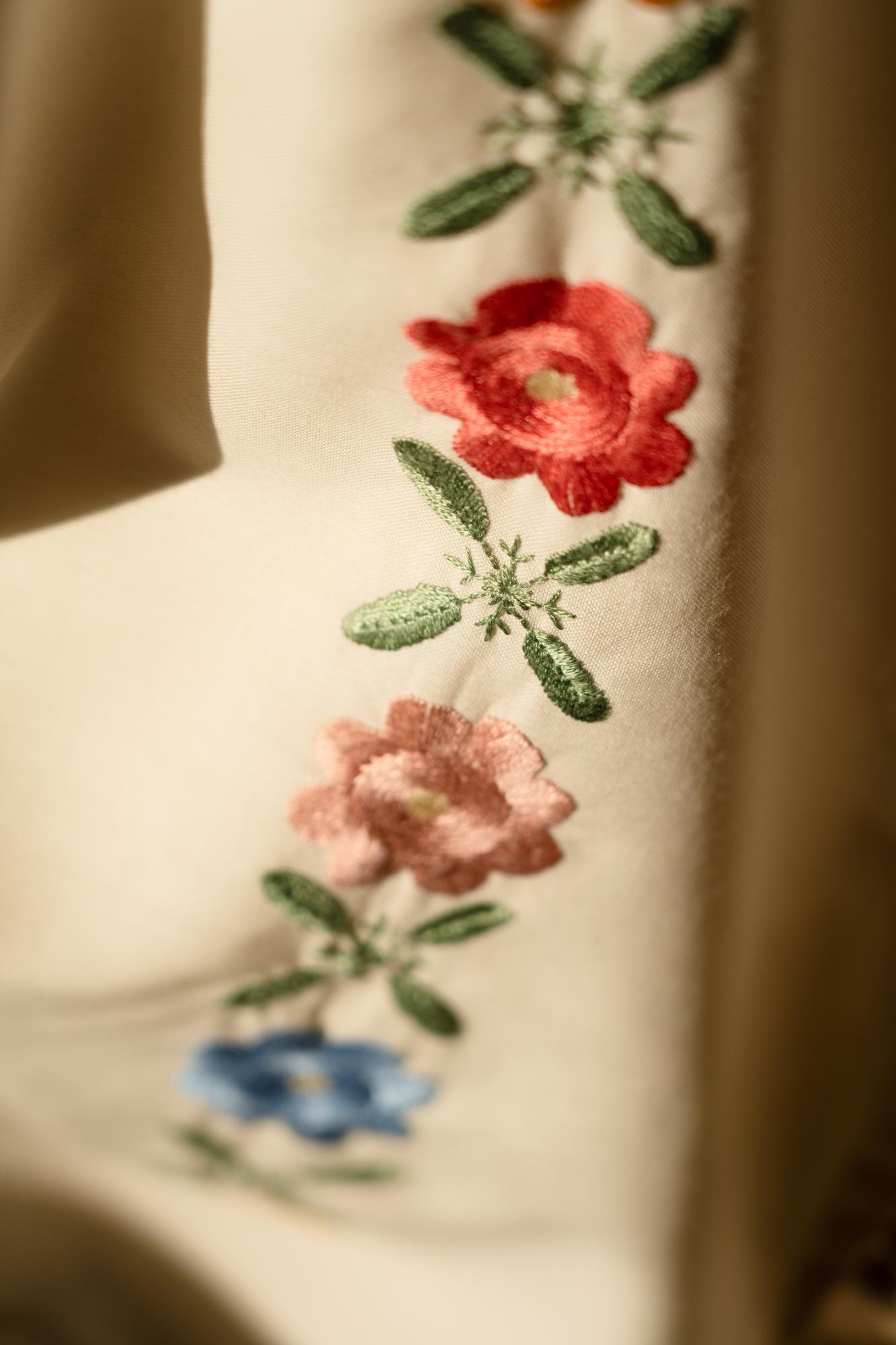 Close-up of embroidered floral stitch on linen